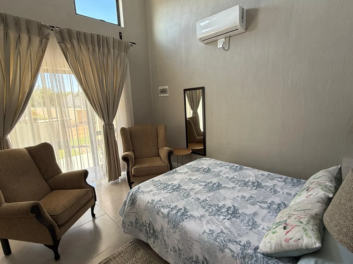 Vertrek met gemakstoele langs die bed